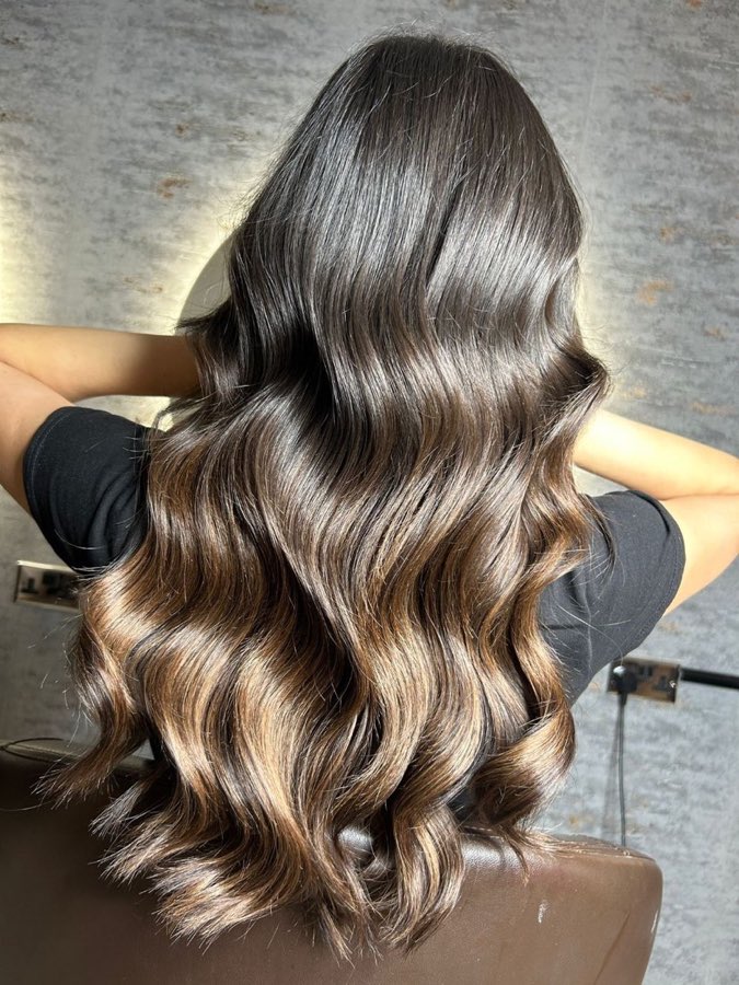 Dark-to-caramel balayage with glossy waves, by Replay Hair & Beauty